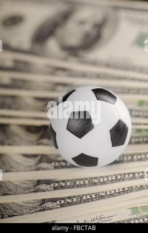 Fußball auf Hintergrund von Dollar Stockfoto