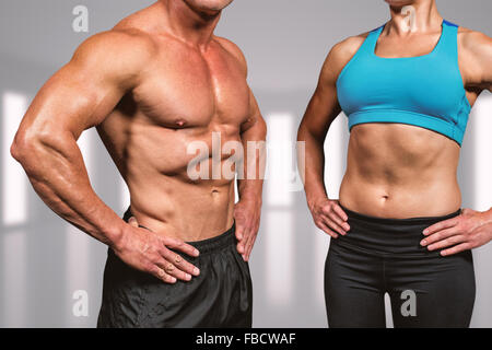 Zusammengesetztes Bild des Mittelteils des muskulösen Mann und Frau mit den Händen auf der Hüfte Stockfoto