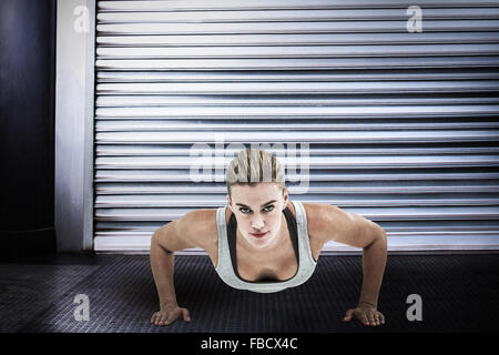 Zusammengesetztes Bild der muskulöse Frau doing Push-ups Stockfoto