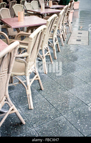 Eine Reihe von Tischen und Stühlen in einem Straßencafé Stockfoto