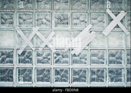 Eine Wand aus Glasbausteinen mit Klebeband geflickt Stockfoto