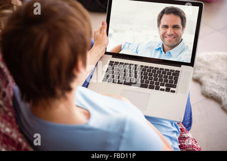 Zusammengesetztes Bild der schwangeren Frau, die mit ihrem laptop Stockfoto