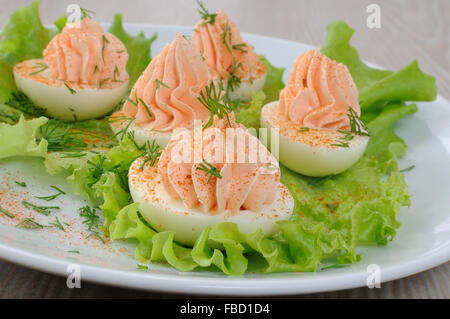 Eiern gefüllte Lachspastete mit rotem Pfeffer in Kopfsalat Blätter Stockfoto