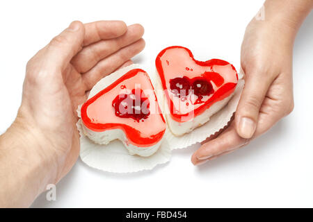 Gelee, herzförmigen Kuchen in Händen der Liebenden auf weißem Hintergrund Stockfoto