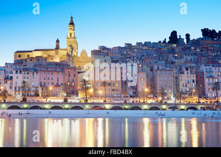 Menton, Altstadt beleuchtet in den Abend, leichte Reflexionen im Meer, Côte d ' Azur Stockfoto