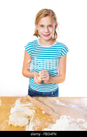 Mädchen knetet den Teig für den Kuchen auf dem Küchentisch isoliert Stockfoto