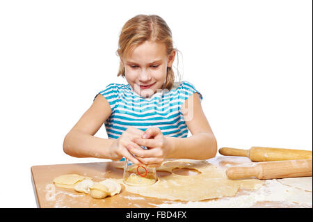 Mädchen knetet den Teig für Knödel auf dem Küchentisch isoliert Stockfoto