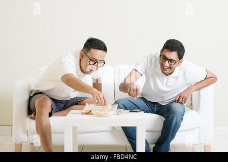 Männer sprechen Konzept. Zwei jungen männlichen Freund treffen, plaudern und Essen zu Hause. Gemischtrassige Menschen Freundschaft. Stockfoto