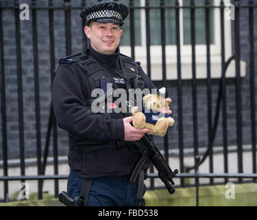 Bewaffnete Polizei Pose mit "Bobby Bär" an Nummer 10 Downing Street.  Mitwirkende: Bewaffnete Polizei, Bobby Bär wo: London, Vereinigtes Königreich bei: 15. Dezember 2015 Stockfoto