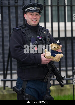 Bewaffnete Polizei Pose mit "Bobby Bär" an Nummer 10 Downing Street.  Mitwirkende: Bewaffnete Polizei, Bobby Bär wo: London, Vereinigtes Königreich bei: 15. Dezember 2015 Stockfoto