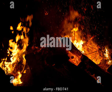 Große Flamme, Glut und Funken ein Feuer in der Nacht Stockfoto