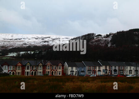 Nant y Moel, Mid Glamorgan, Südwales. 15th. Januar 2016: Blick auf Reihenhäuser im Dorf Nant y Moel im oberen Ogmore Valley in Südwales, mit frischem Schneefall auf den Mynydd Llangeinwyr Hügeln dahinter. Mehrere Zentimeter Schnee fielen über Nacht auf die Hügel, was das Met Office dazu veranlasste, eine Unwetterwarnung über Schnee und Eis für die Region mit gelbem Niveau auszustellen. Quelle: James Brunker/Alamy Live News Stockfoto