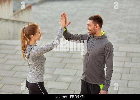 glückliches Paar geben hohe fünf im freien Stockfoto