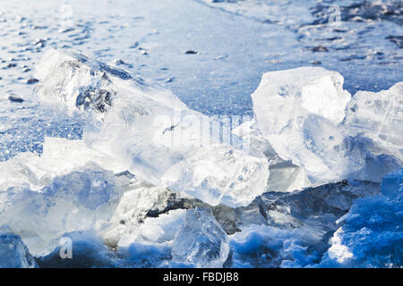 Eisblöcke beleuchtet von Sun am Rande des Eisloch im zugefrorenen See in kalten Wintertag Stockfoto