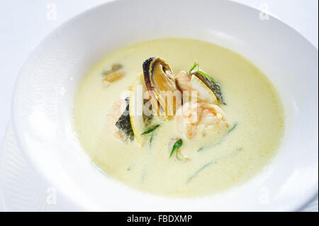 Safran-Suppe mit Meeresfrüchten auf weißen Teller Studio gedreht Stockfoto