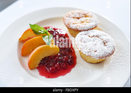 Quark-Kuchen mit Cranberry-Sauce und Pfirsich Stockfoto