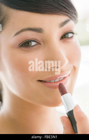 Junge Frau Auftragen von Lippenstift, Nahaufnahme Stockfoto