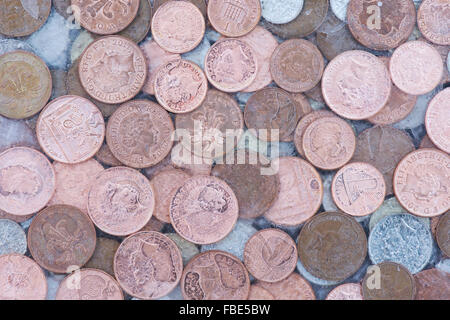 Münzen in Eis Stockfoto