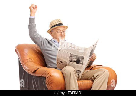 Ältere Gentleman Lesen der Nachrichten und feiert mit der Faust in die Luft isoliert auf weißem Hintergrund Stockfoto