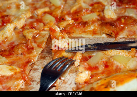 schmackhafte appetitliche Pizza schneiden mit Messer und Gabel Stockfoto