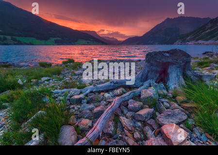 Schöne Aussicht auf den See Resia. Dramatischer Himmel und farbenprächtigen Sonnenuntergang. Alpen, Italien, Europa. Stockfoto