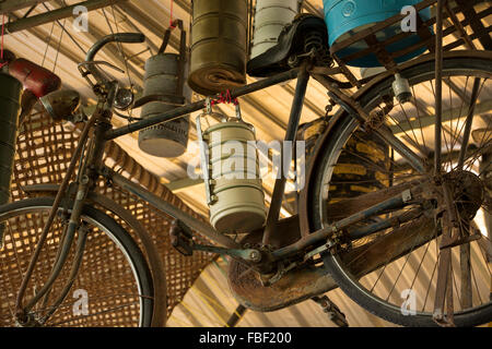 Antikes Fahrrad und sortierten Tiffin Behälter hängen von der Decke, im Hinterzimmer eines Restaurants in Georgetown, Penang. Stockfoto