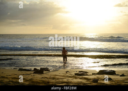 Surfer im Wasser bei einem atemberaubenden Sonnenuntergang am Strand von Maria erhalten. Rincón, Puerto Rico. Territorium der USA. Karibik-Insel. Stockfoto