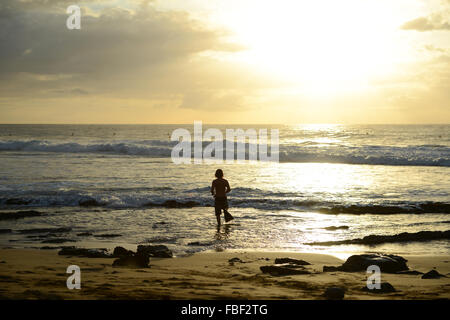 Surfer im Wasser bei einem atemberaubenden Sonnenuntergang am Strand von Maria erhalten. Rincón, Puerto Rico. Territorium der USA. Karibik-Insel. Stockfoto