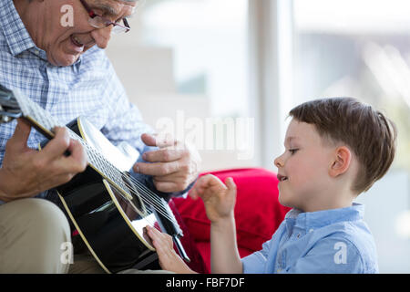 Großvater lehrt Enkel, Gitarre zu spielen Stockfoto