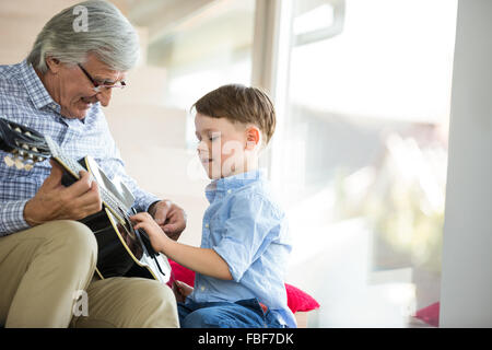 Großvater lehrt Enkel, Gitarre zu spielen Stockfoto