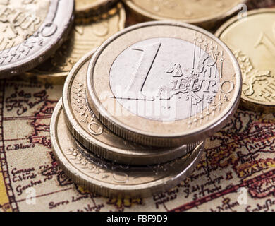 Euro-Münzen über die alte Weltkarte. Makro-Bild. Stockfoto