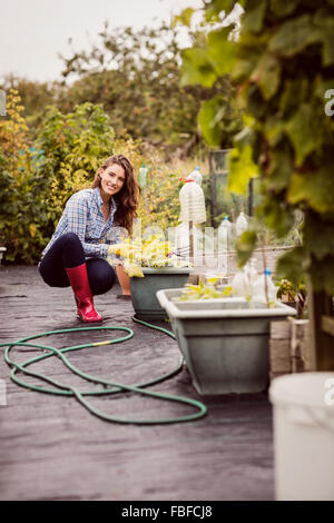 Frau betrachten Blumenbeet Stockfoto