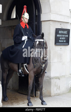 Household Cavalry Wachposten neben einem Schild mit der Aufschrift "Achtung Pferde können kick oder beißen Danke" Stockfoto