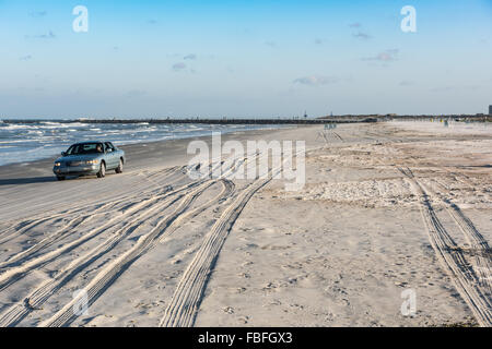 Blau Limousine in Richtung Kamera fahren am Strand in der Nähe der atlantischen Ozean in Ponce Inlet Lighthouse Park mit Reifenspuren und Verkehrszeichen in der Nähe von Daytona Beach. Stockfoto