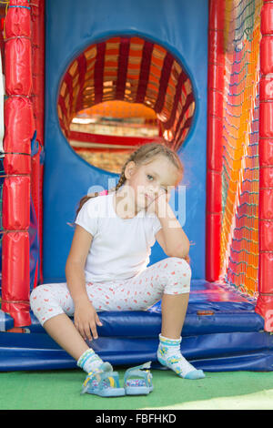 Müde, aber glücklich drei Jahre alten Mädchen sitzen auf der Schwelle zu einer weichen Spielzimmer Stockfoto