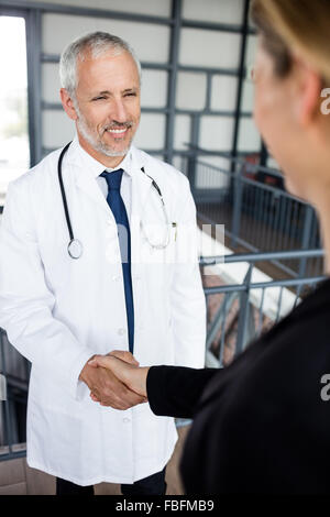 Geschäftsfrau und Arzt machen einen Händedruck Stockfoto