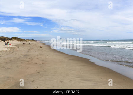 Menschen mit einer langen Reihe Schlepper Angeln Maschine auf Papamoa Beach, Bay of Plenty, New Zealand Angeln. Stockfoto