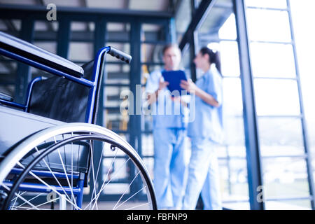 Krankenschwester-Mitarbeiter bringen einen Rollstuhl Stockfoto