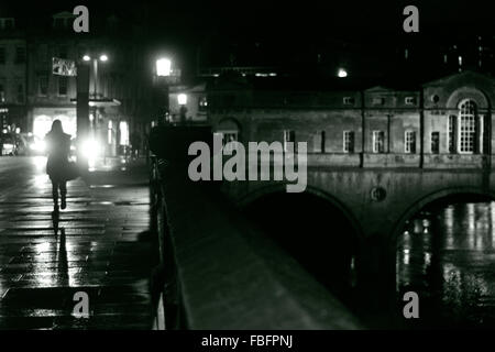 Frau im Bad an einem regnerischen Abend. Eine Frau geht durch Pulteney Bridge in die UNESCO-Stadt Bath Stockfoto