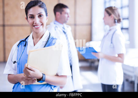 Lächelnd hält Bericht über Zwischenablage Krankenschwester Stockfoto