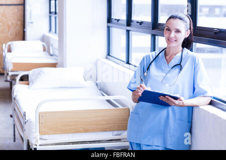 Lächelnd hält Bericht über Zwischenablage Krankenschwester Stockfoto