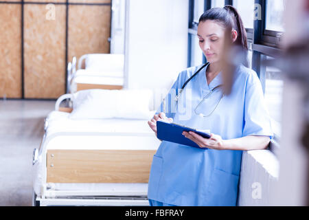 Ernsthafte Krankenschwester hält Bericht über die Zwischenablage Stockfoto