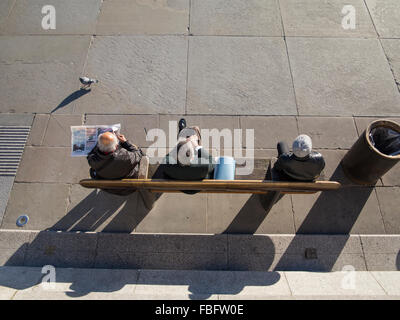 Die Zeitung lesen und beobachten das bunte Treiben in London auf einer Bank sitzen Stockfoto