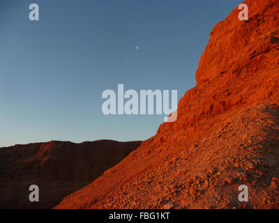 Wandern Masada in Israel bei Sonnenaufgang mit dem Sonnenlicht wirft eine rote anschlagen die Sandsteinfelsen Stockfoto