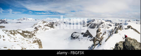 Bergsteiger auf Berggipfel und schneebedeckte Grate in großer Höhe im italienischen französische Alpenbogen. Malerischen Himmel und Wolken coveri Stockfoto