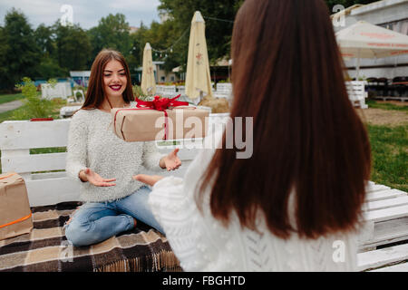 Mädchen wirft Geschenke zueinander Stockfoto