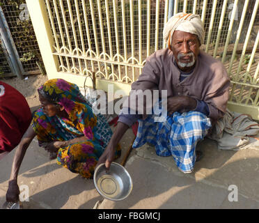 Männliche und weibliche Bettler sitzen vor einem Tempel in Indien Stockfoto