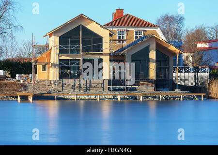 Karlskrona, Schweden - 13. Januar 2016: Ein Hausbau-Website mit ein fast fertiges Haus. Menschen im Inneren arbeiten. In der Nähe Stockfoto