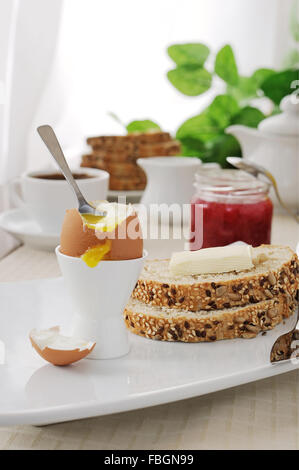 Wachsweiches Ei mit Haferflocken Brot mit Butter zum Frühstück Stockfoto