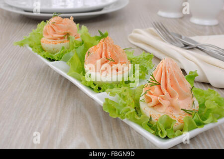 Eiern gefüllt mit Pastete Lachs mit Paprika in Kopfsalat Blätter Stockfoto